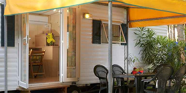 Terrazzo esterno coperto della casa mobile arredato con tavolo e sedie