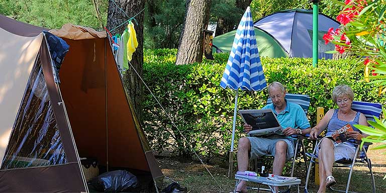 Piazzola con tenda con tavolo e sedie e posto auto